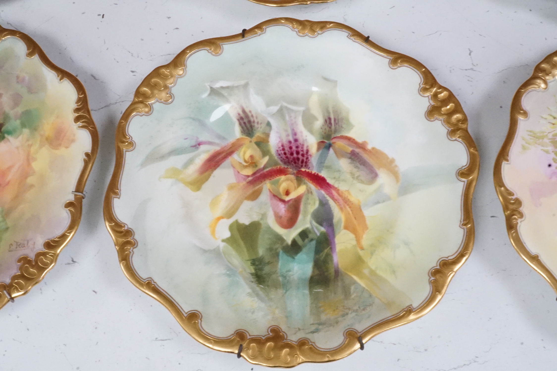 Six Royal Doulton floral painted plates, three signed E. Raby and three signed D. Dewsberry